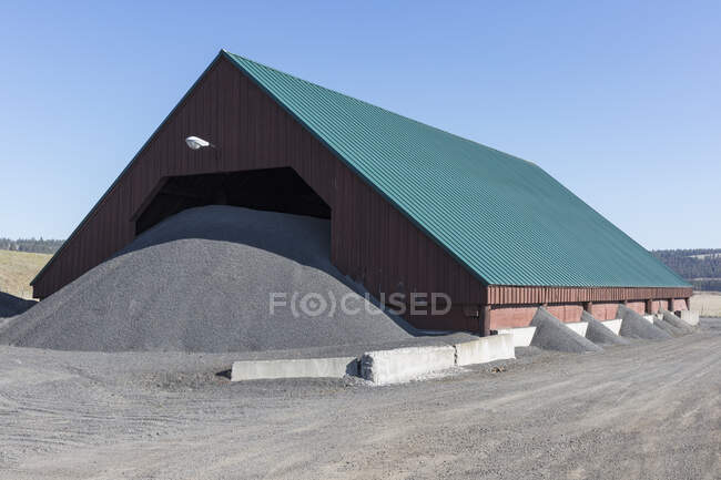 Barn and gravel pile used for road construction and maintenance — Stock Photo
