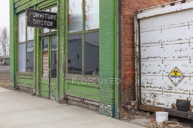 Immeuble abandonné sur une rue principale, enseigne de médecin de meubles au-dessus de la porte d'entrée, atelier de réparation — Photo de stock