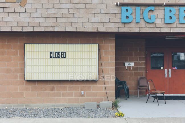 CLOSED sign in front of a building on a deserted main street. — Fotografia de Stock