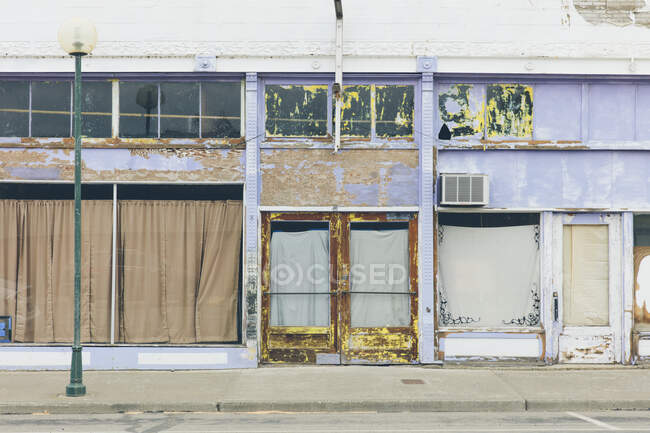 Главная улица в городе, заброшенные лавочки, с заколоченными окнами, закрытый бизнес — стоковое фото
