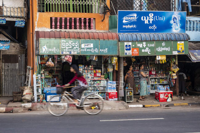 Mawlamyine, frentes de tiendas y motocicletas en la carretera - foto de stock