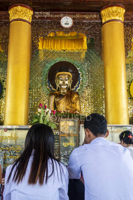 Молитва у статуи Будды в пагоне Шведагон Мьянма — стоковое фото