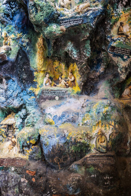 Ancien temple avec des statues de Bouddhas et sculpture religieuse sur pierre calcaire dans la grotte sacrée de Kaw Goon près de Hpa-An au Myanmar — Photo de stock
