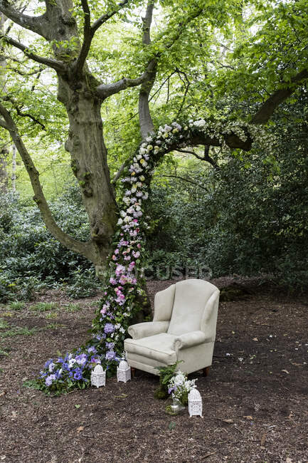Poltrona e flor guirlanda decorações para uma cerimônia de nomeação floresta. — Fotografia de Stock