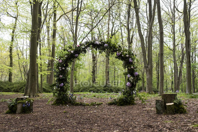 Arch with pink flower decorations for a woodland naming ceremony. — Stock Photo