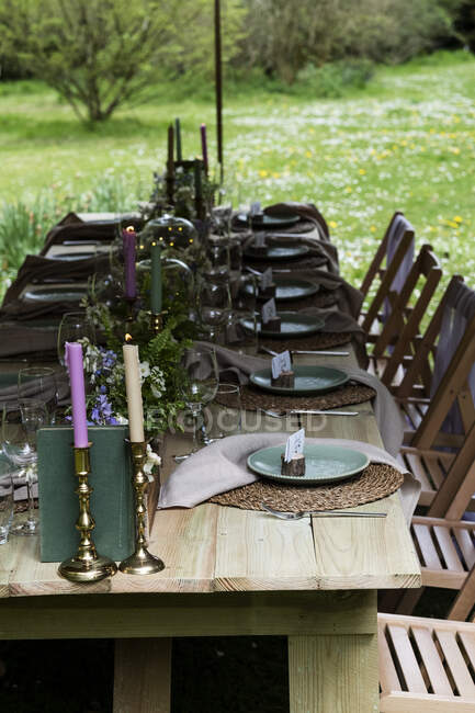 Mesa de comedor con velas y ambientes rústicos para una ceremonia de denominación de los bosques. - foto de stock