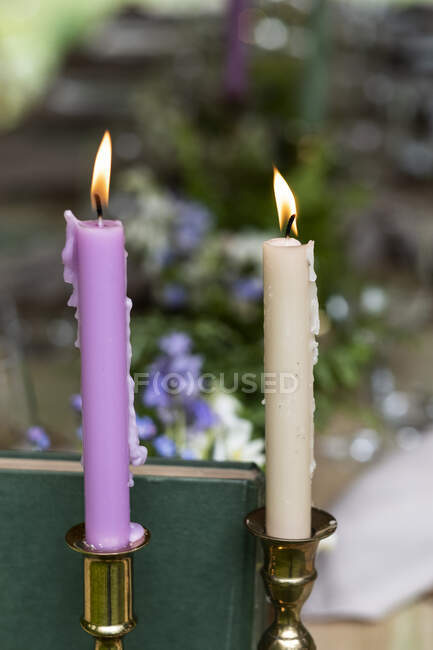 Primo piano di candele rosa e crema, decorazioni per una cerimonia di denominazione boschiva. — Foto stock