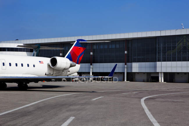 Edificios del aeropuerto y un avión de pasajeros en tierra - foto de stock