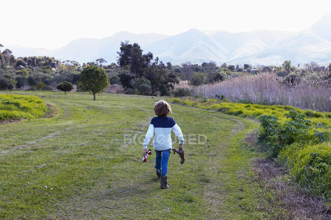 Young boy on nature trail, Klein River, carrying a toy truck and dinosaur — Stock Photo