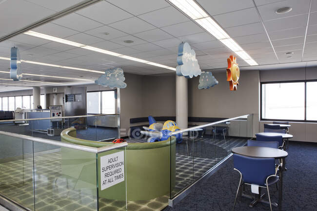 Uma área de jogos infantil do lounge de partida do aeroporto com sinais. Mesas e cadeiras. — Fotografia de Stock