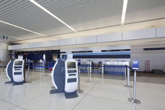 Mostradores de facturación y mostradores de facturación de equipaje tradicionales en un aeropuerto vacío. - foto de stock