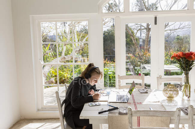 Teenage ragazza pittura con acquerelli a un tavolo — Foto stock