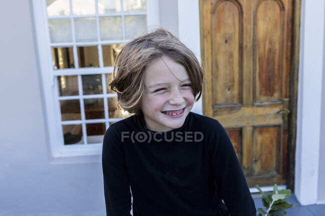 Молодий хлопчик сміється, дивиться вбік, голова і плечі — стокове фото