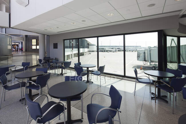 Café con vistas al delantal del aeropuerto, y puertas de llegadas y salidas. - foto de stock