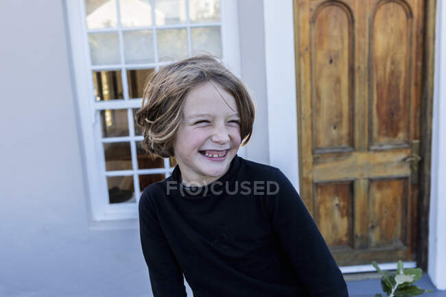 Мальчик смеется, боком глядя, головой и плечами — стоковое фото