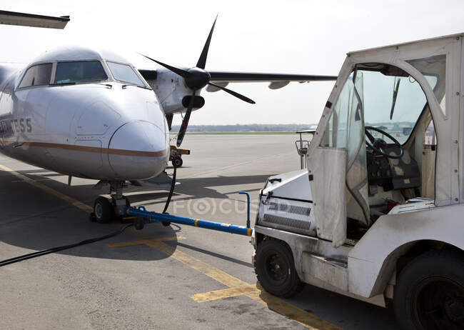 Airport vehicle towing a propeller aircraft into position — Stock Photo