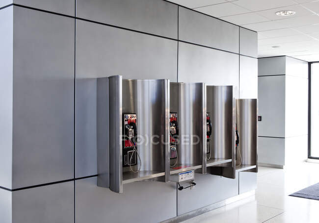 A row of public telephones in booths at an airport. — Stock Photo