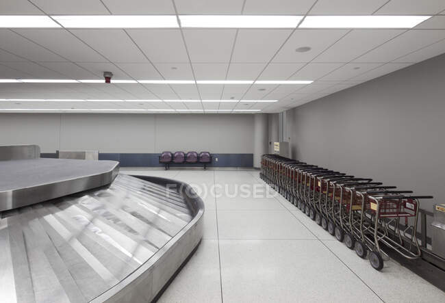 Área vazia de bagagem do aeroporto, carrosséis e carrinhos. — Fotografia de Stock