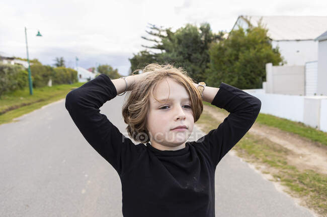 Ragazzo di otto anni, mani sopra la testa, ritratto — Foto stock