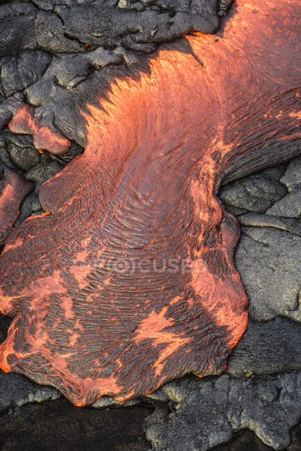 Lava fluindo sobre rocha negra vulcânica. — Fotografia de Stock