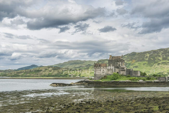 Eilan Donan, um castelo remoto em uma ilha de maré com maré baixa. — Fotografia de Stock