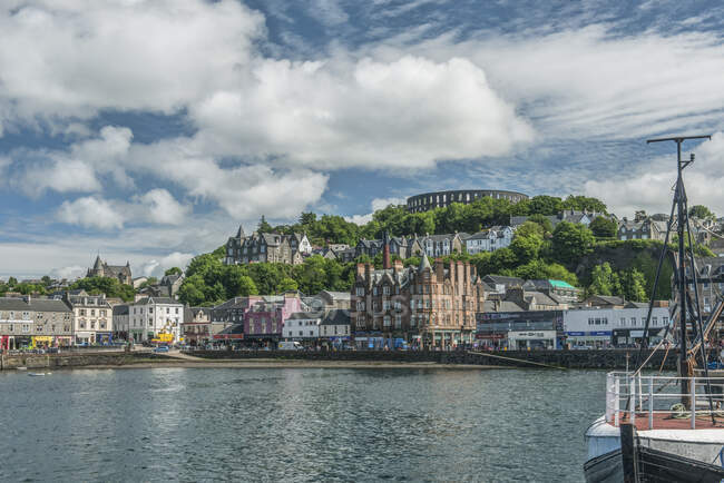 Waterfront town with Coliseum-style monument on hilltop, Mccaig's Tower and Battery. — Stock Photo