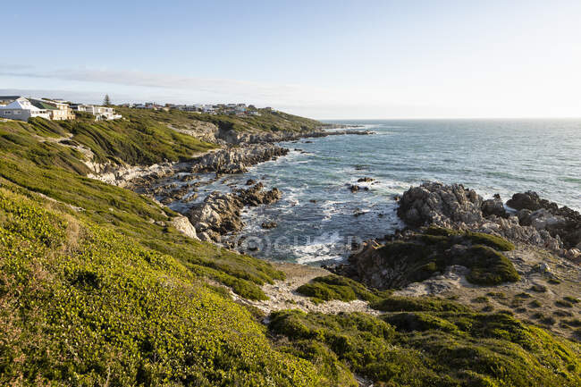 Vista desde arriba de una costa rocosa dentada, acantilados y camino a la playa y al mar. - foto de stock