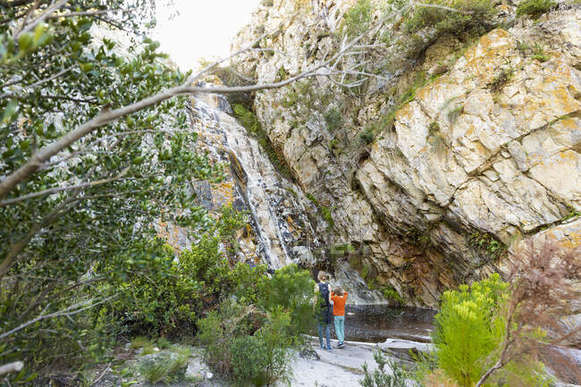 Adolescente e irmão mais novo caminhando pela trilha da cachoeira, Stanford, África do Sul. — Fotografia de Stock