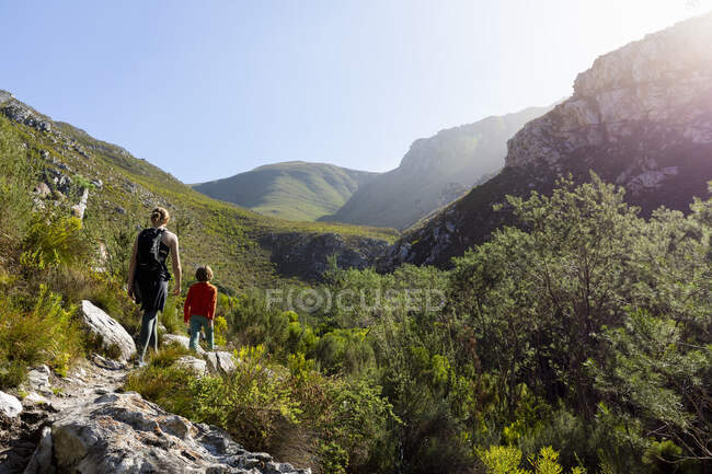 Adolescente e irmão mais novo caminhando pela trilha da cachoeira, Stanford, África do Sul. — Fotografia de Stock
