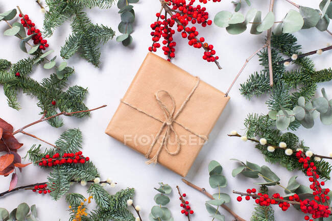Christmas decorations on a white background and a gift wrapped present — Stock Photo
