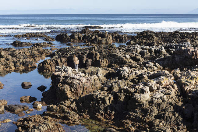 A teenage girl exploring the rock pools on the Atlantic Ocean coastline, De Kelders, Western Cape, South Africa. — Stock Photo