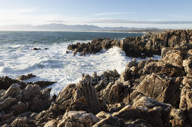 Jagged rocks on the Atlantic ocean coastline and white water waves breaking. — Stock Photo