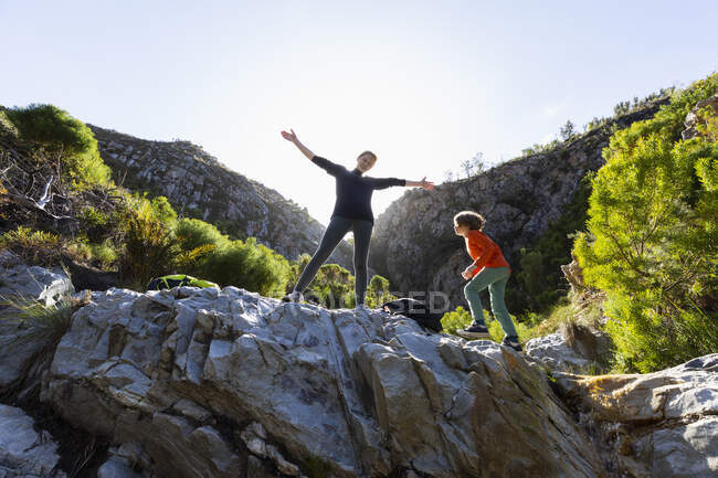 Adolescente y hermano menor haciendo senderismo en el Sendero de la Cascada, Stanford, Sudáfrica. - foto de stock