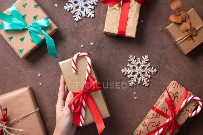 Navidad, vista aérea de regalos envueltos y decoraciones en una mesa - foto de stock