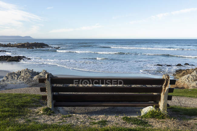 Panchina con vista su una spiaggia, scogli frastagliati e piscine rocciose sulla costa atlantica. — Foto stock