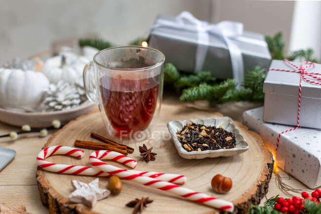 Christmas, a glass of mulled cider or wine with spices, candy canes and decorations. — Stock Photo