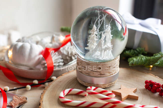 Weihnachtsdekoration, eine Schneekugel und Geschenke und sternförmige Kekse. — Stockfoto