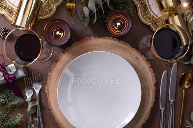 Рождество, сервировка стола, вид сверху, вино и свечи, тарелки и столовые приборы — стоковое фото