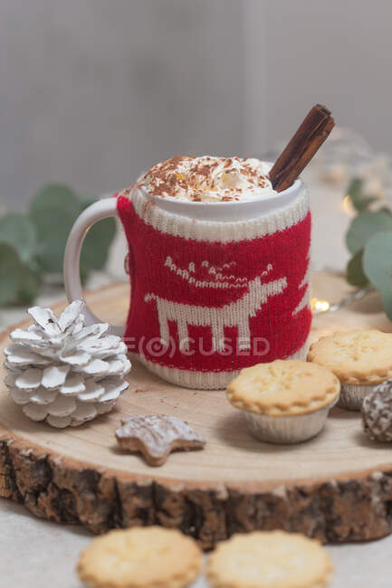 Christmas, a mug of hot chocolate or eggnog with a knitted wraparound cozy and mince pies. — Stock Photo