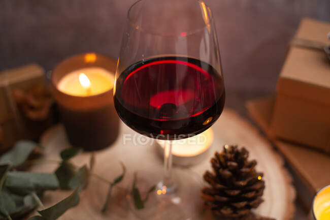 Navidad, copas de vino con especias, velas encendidas y decoraciones de mesa - foto de stock