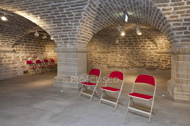 Cadeiras em uma sala de pedra abobadada para reuniões de palestras ou seminários em uma universidade — Fotografia de Stock