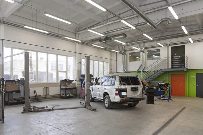 SUV em uma grande oficina de reparação ou garagem. — Fotografia de Stock
