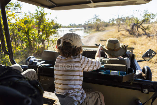 Menino em veículo de safári ao nascer do sol, Okavango Delta, Botsuana. — Fotografia de Stock