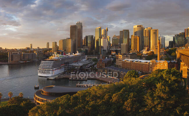 Kreuzfahrtschiff legt im Hafen von Sydney an, dahinter Wolkenkratzer. — Stockfoto