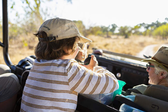Молодий хлопчик в автомобілі сафарі на світанку, дельта Окаванго, Ботсвана.. — стокове фото