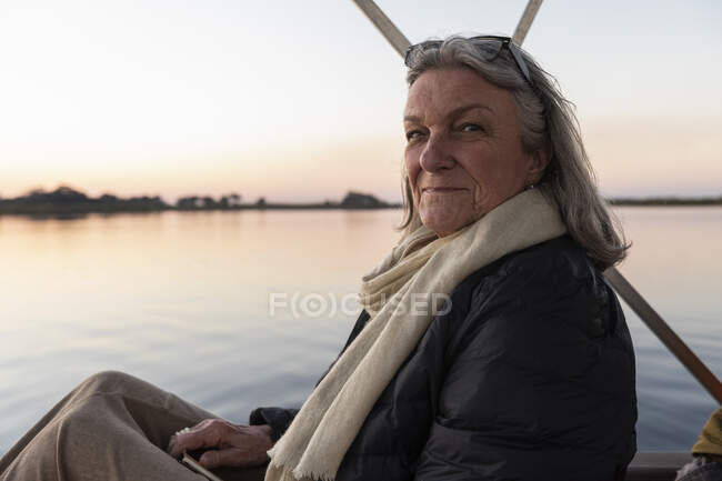 Senior woman on the Okavango Delta, Botswana at sunset, Botswana. — Stock Photo