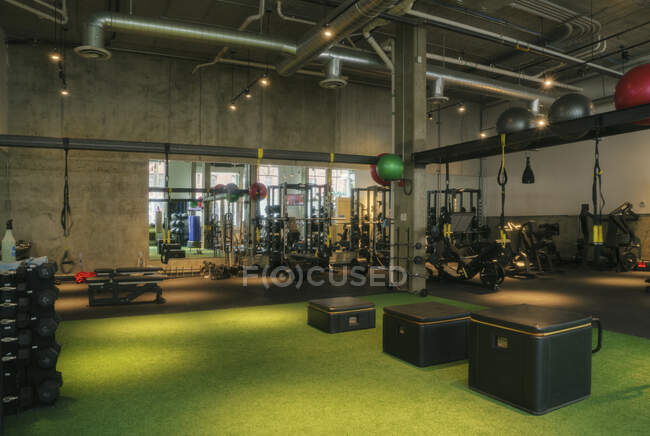 Sala de pesas y equipo de ejercicio en un gimnasio vacío. - foto de stock