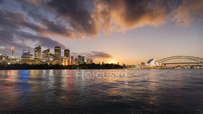 Sydney si illuminò all'alba vista dall'acqua, inclusa la Sydney Opera House. — Foto stock