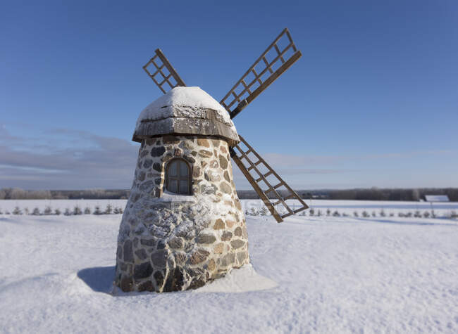Vecchio mulino a vento in pietra sul paesaggio innevato in inverno. — Foto stock