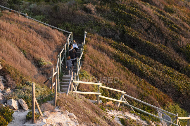 Family climbing stairs, Walker Bay Reserve, Sudáfrica - foto de stock